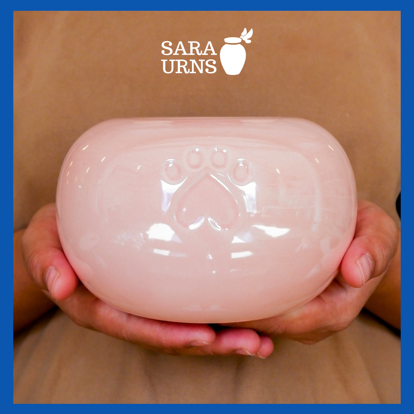 A presentation of a pink pearly ceramic pet urn held by an adult woman with two palms.