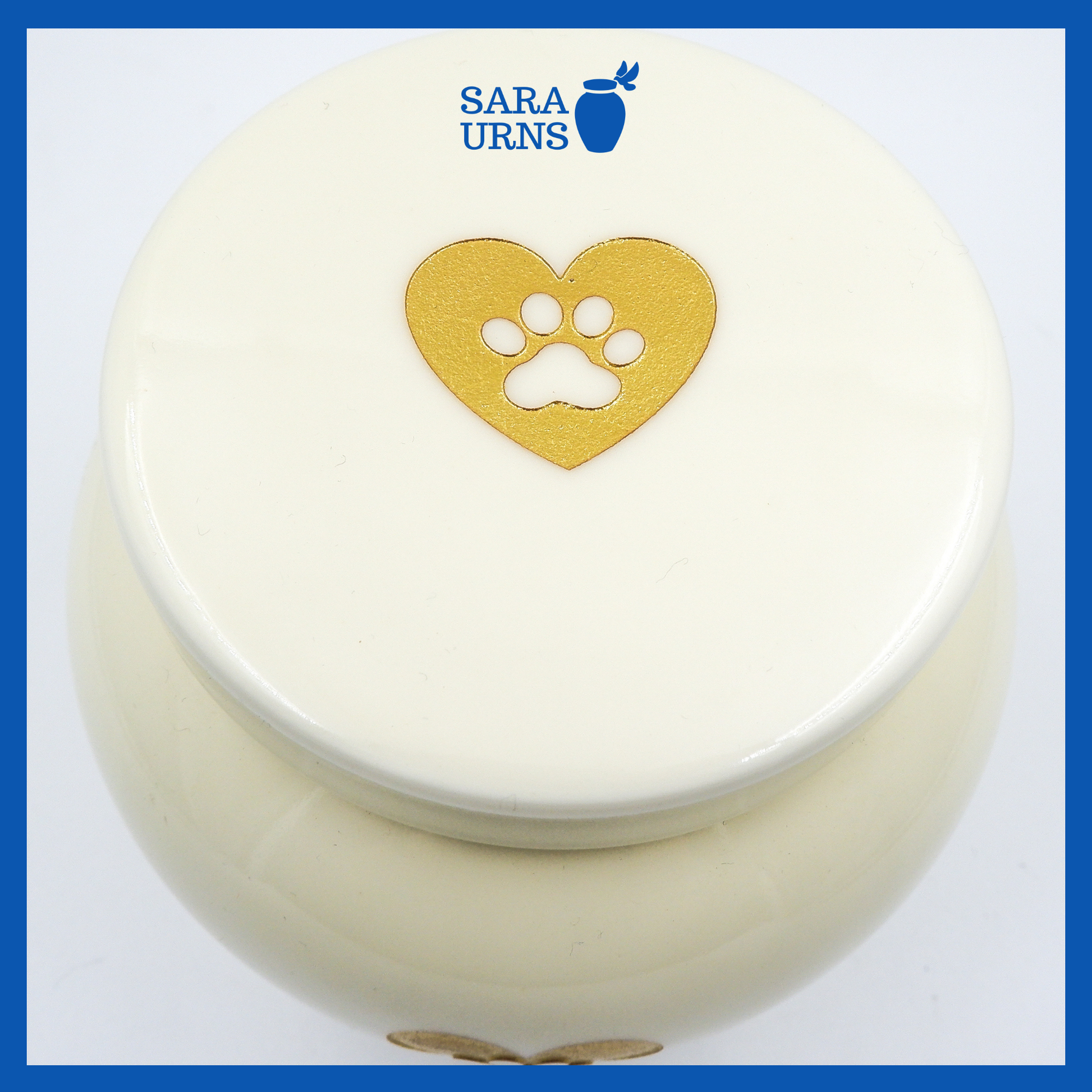 A higher angle of a beige polished ceramic pet urn with a gold metallic foiled heart at its center.