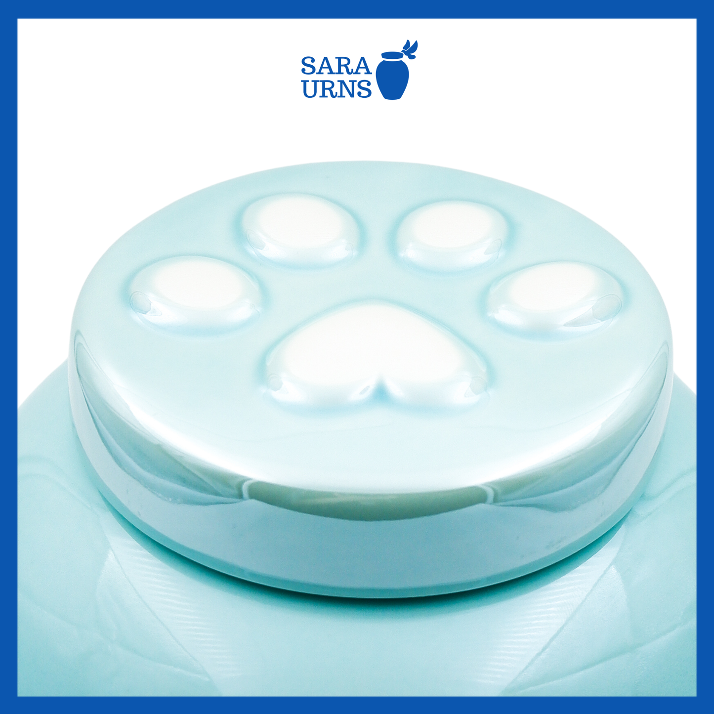 A higher angle of a blue ceramic pet urn with an embossed paw detail in the lid over a white background.
