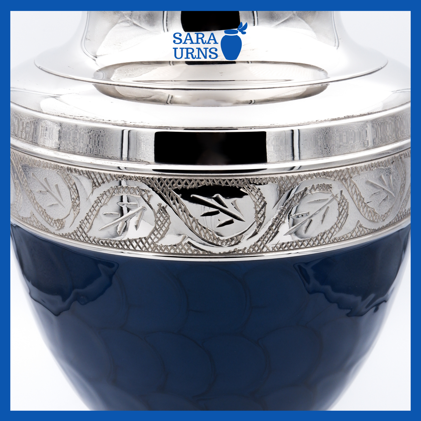 A close-up angle of a dark blue polished brass metal urn which highlights its enamel finish and silver hand-etched details.