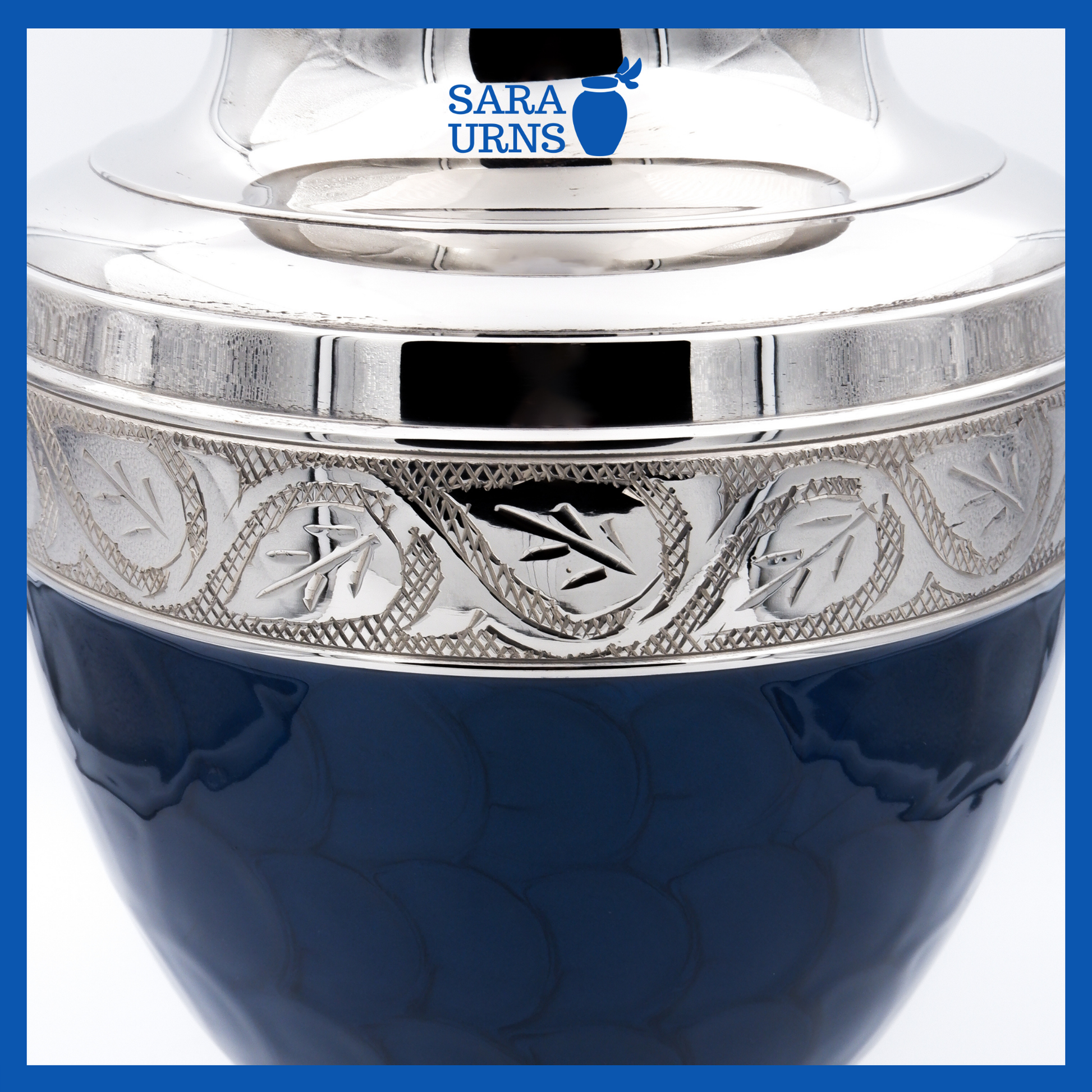 A close-up angle of a dark blue polished brass metal urn which highlights its enamel finish and silver hand-etched details.