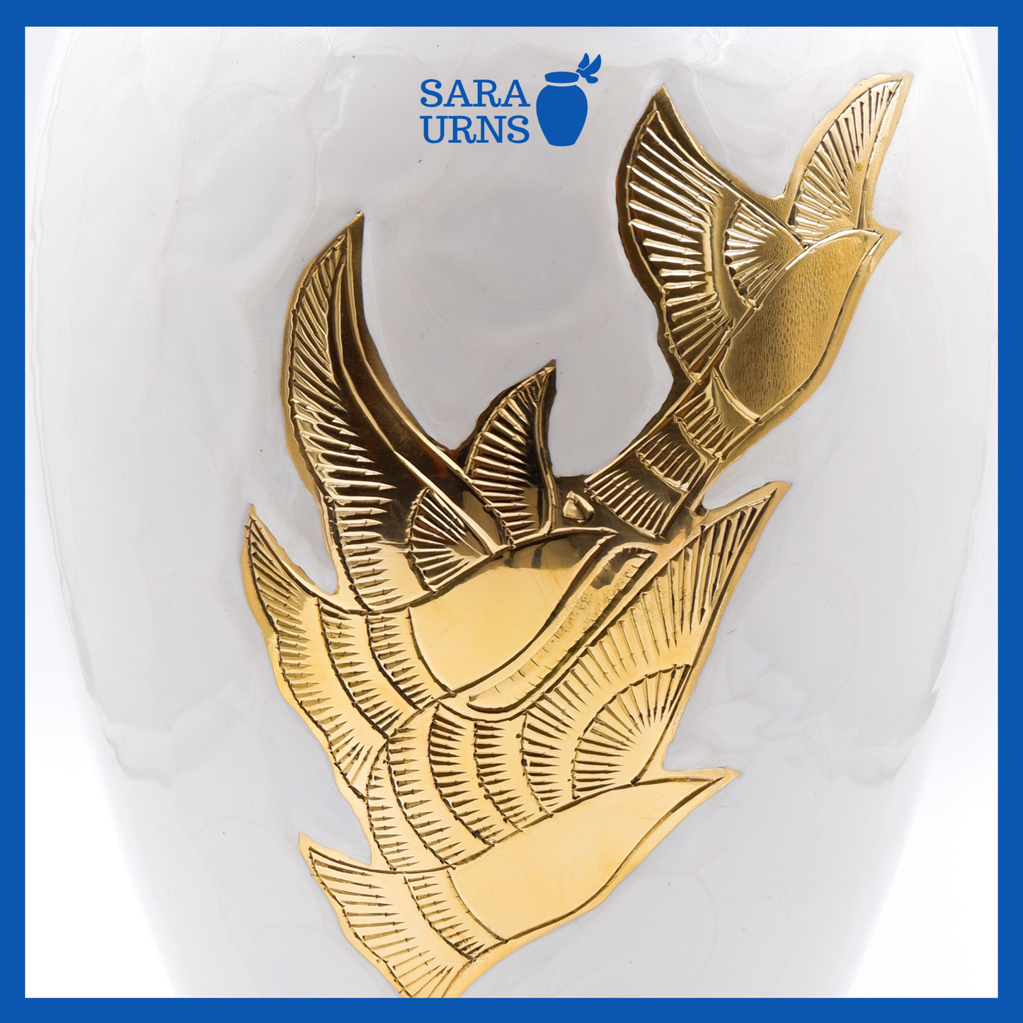 A close-up angle of a white polished brass metal urn which highlights its enamel finish and golden, hand-etched winged doves.