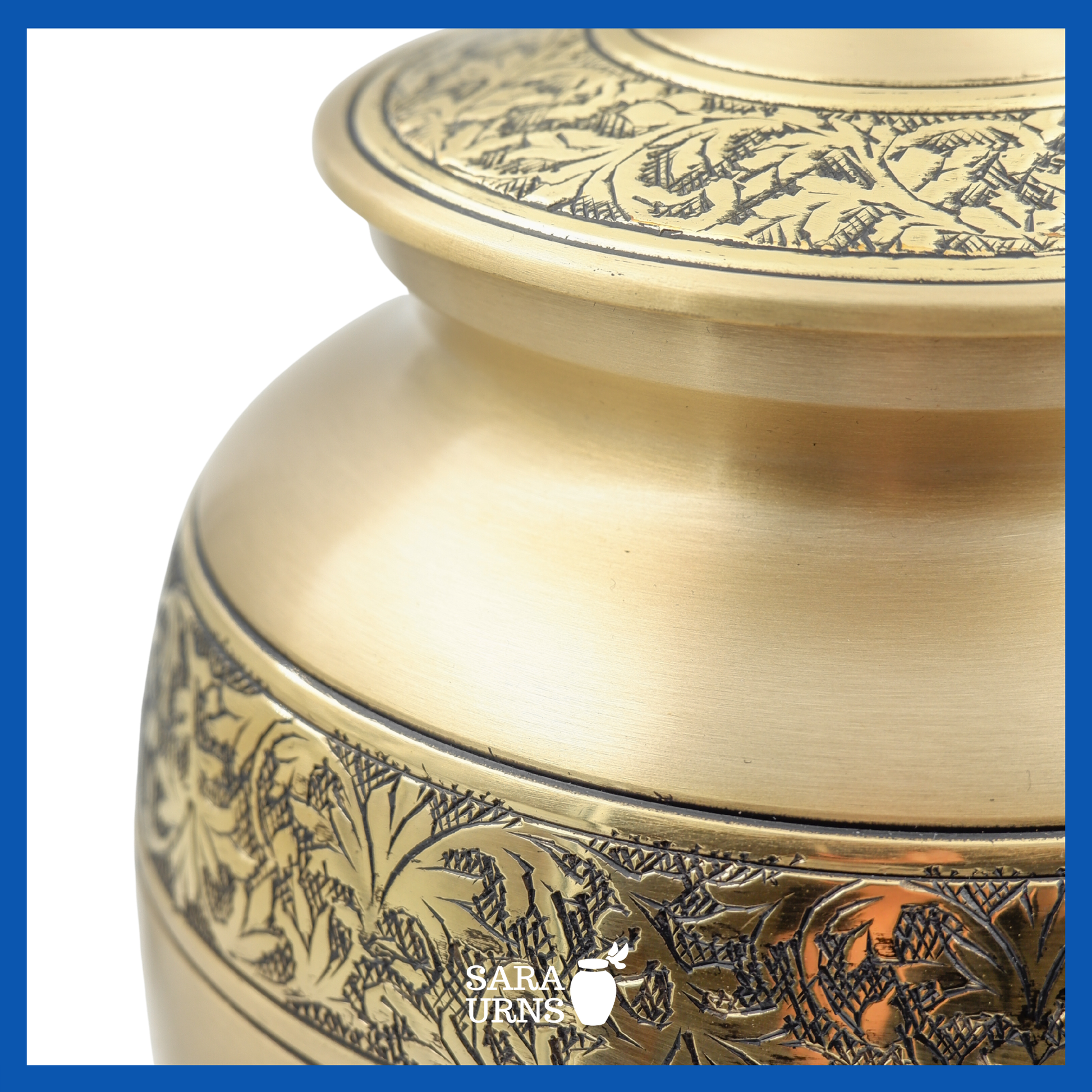 A close-up angle of a gold polished brass metal urn which highlights its hand-etched details on its body and lid.
