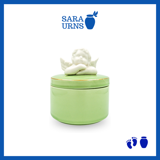 A green polished ceramic baby urn with a cherub lid over a white background.