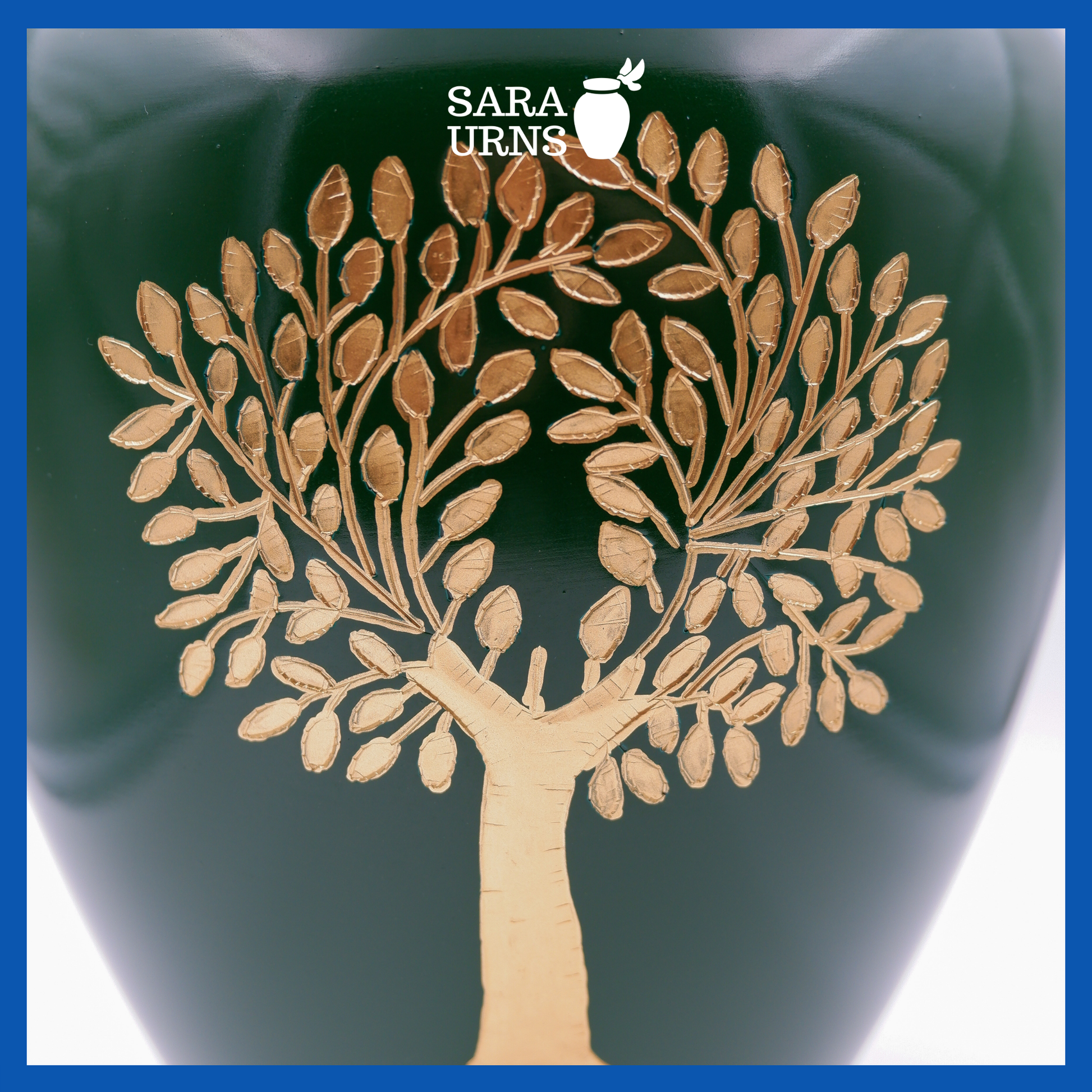 A close-up angle of a green polished brass metal urn which highlights its green polished finish and golden, hand-etched tree of life detail.