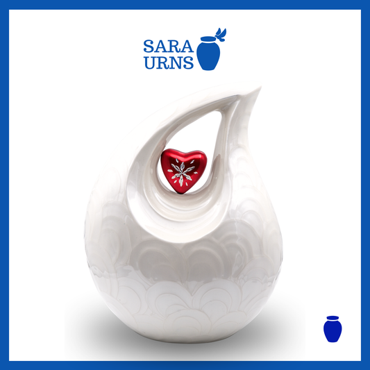 A white polished aluminum metal urn with a droplet shape and heart centerpiece over a white background.