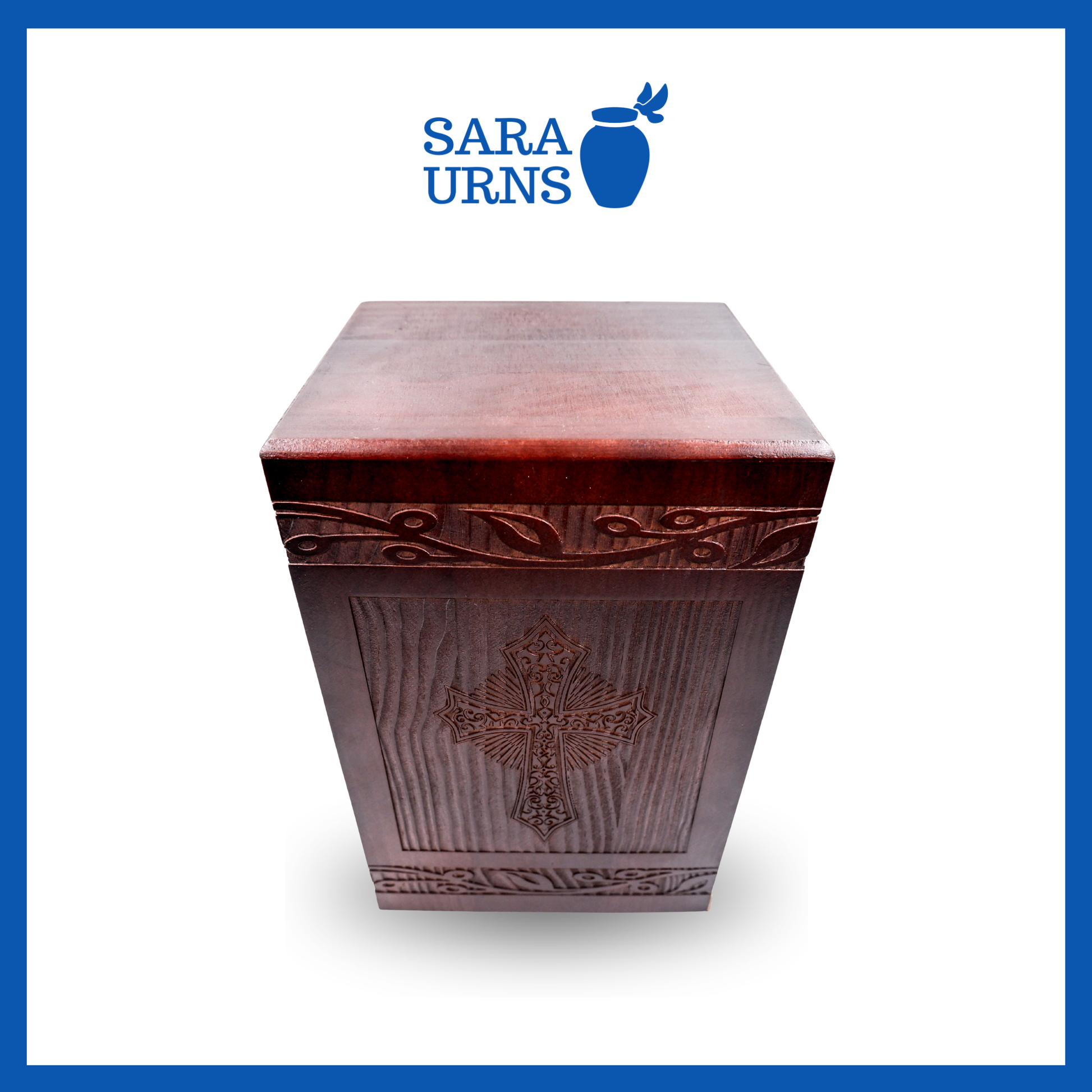 A higher angle of a brown pine wooden keepsake urn with an intricate engraving of the holy cross over a white background.