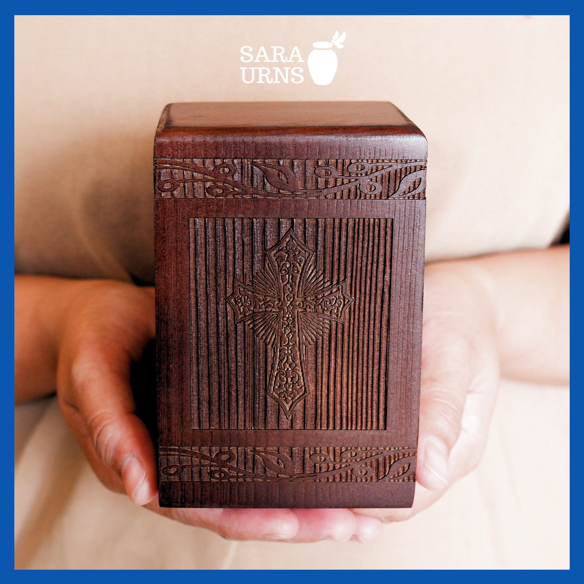 A presentation of a brown pine wooden keepsake urn with an intricate engraving of the holy cross held by an adult woman with two palms.