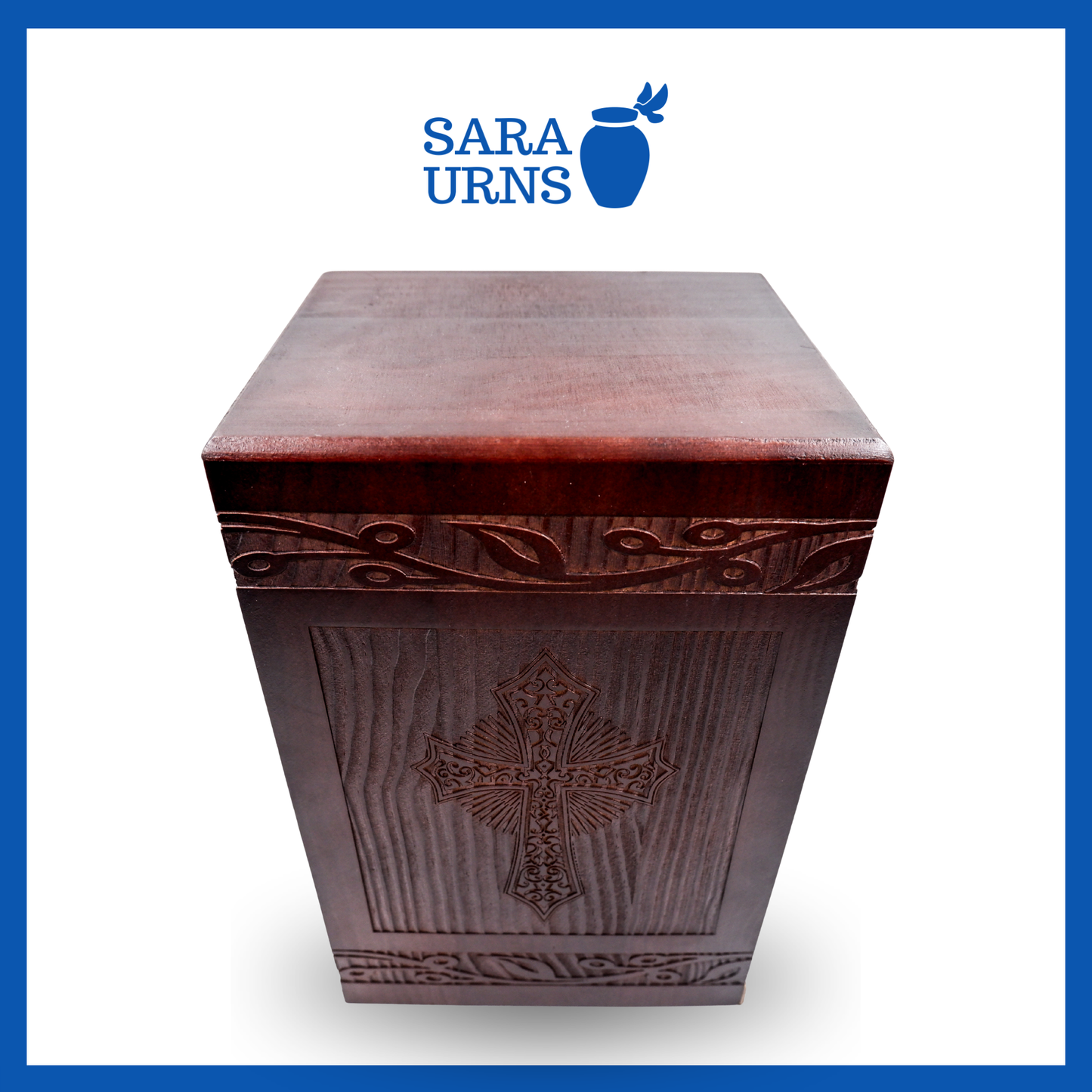 A higher angle of a brown pine wooden urn with an intricate engraving of the holy cross over a white background.