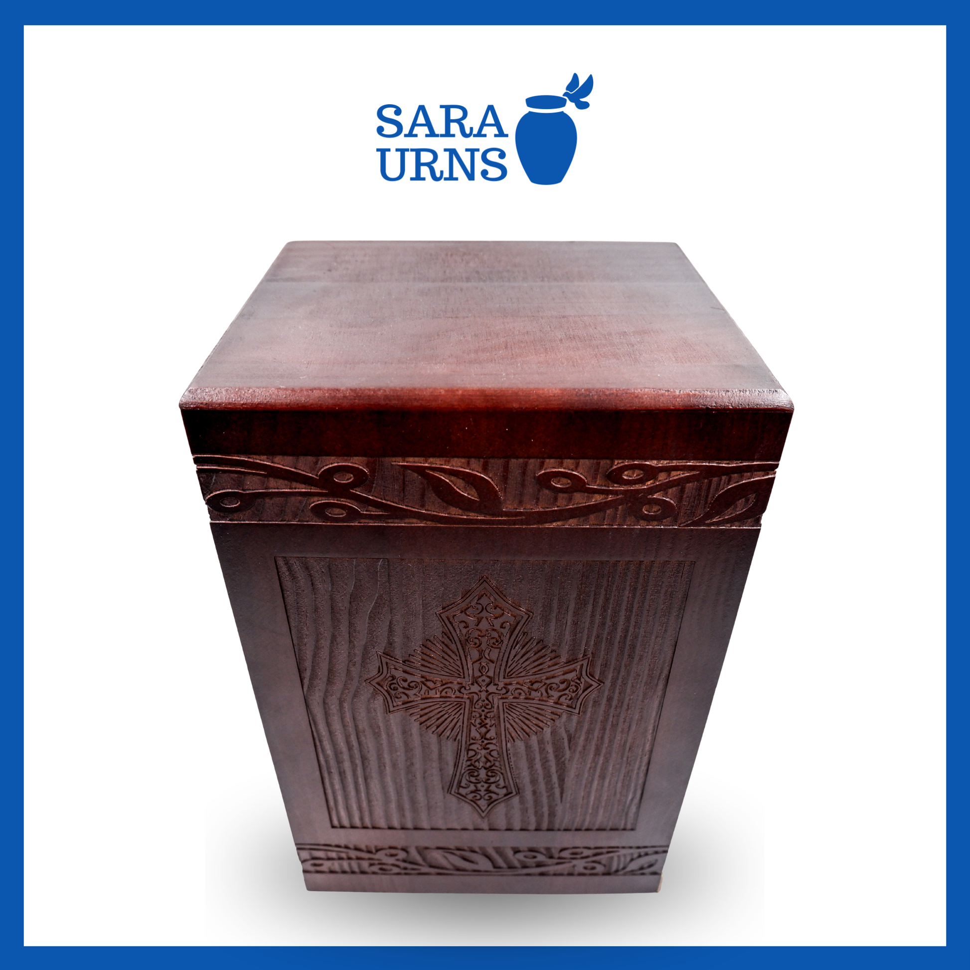 A higher angle of a brown pine wooden urn with an intricate engraving of the holy cross over a white background.