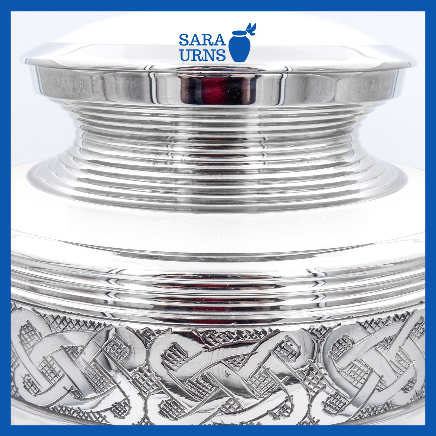 A close-up of a white polished brass metal urn which highlights its silver hand-etched knot details.
