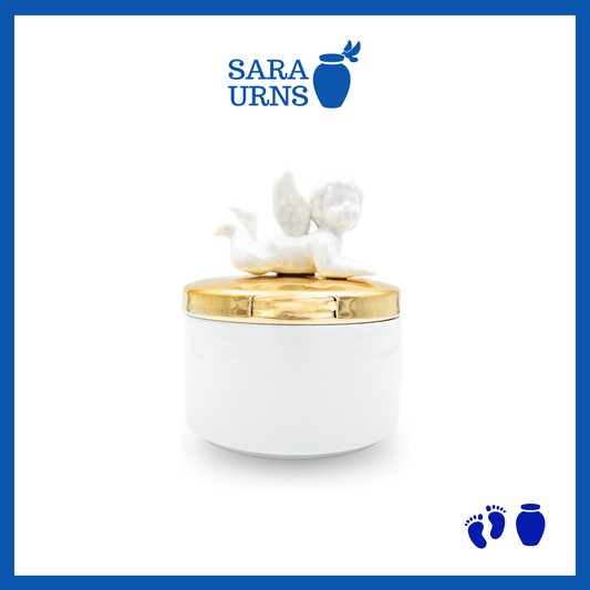 A white polished ceramic baby urn with a gold lid and cherub design over a white background.