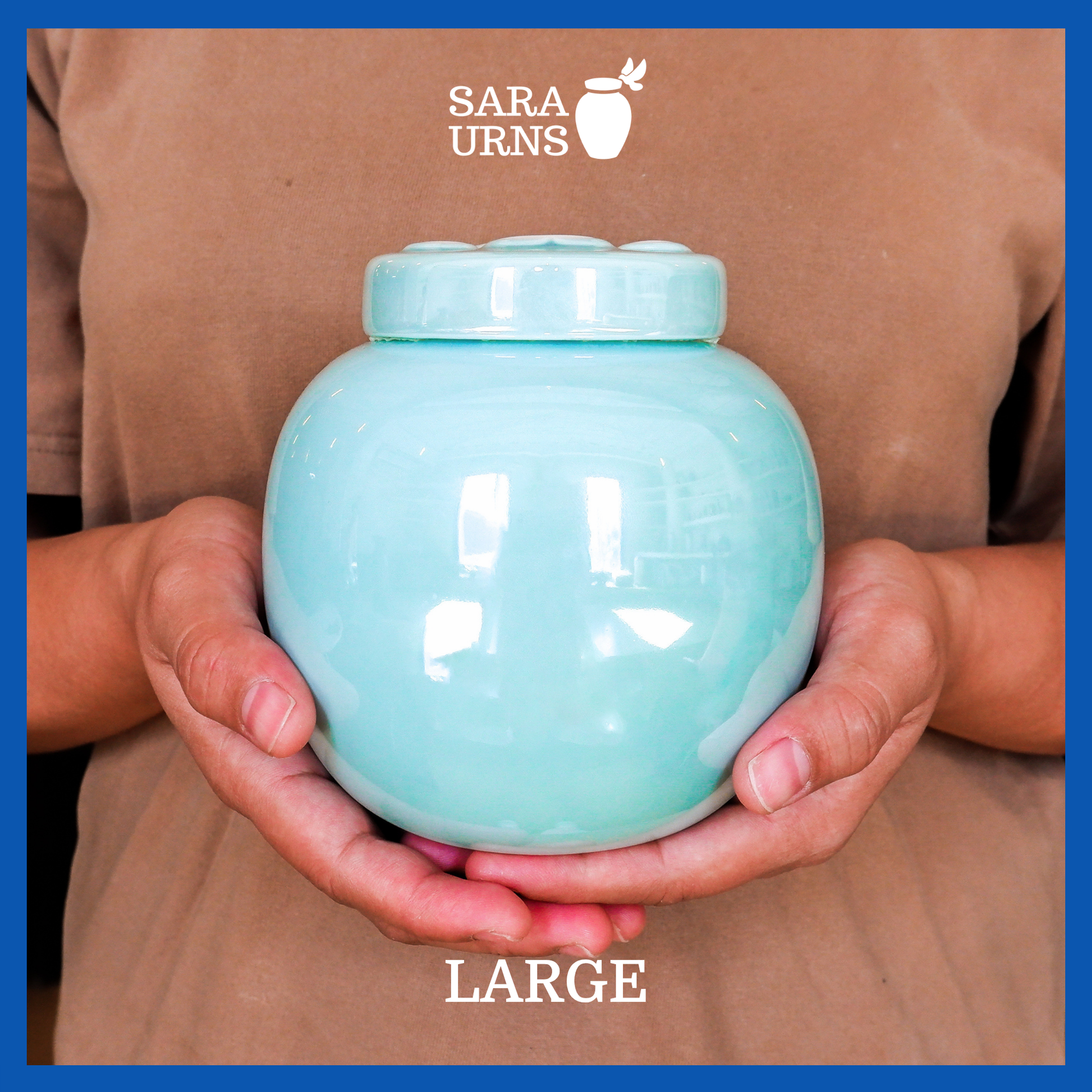 A presentation of a large, blue pearly ceramic pet urn held by an adult woman with two palms.