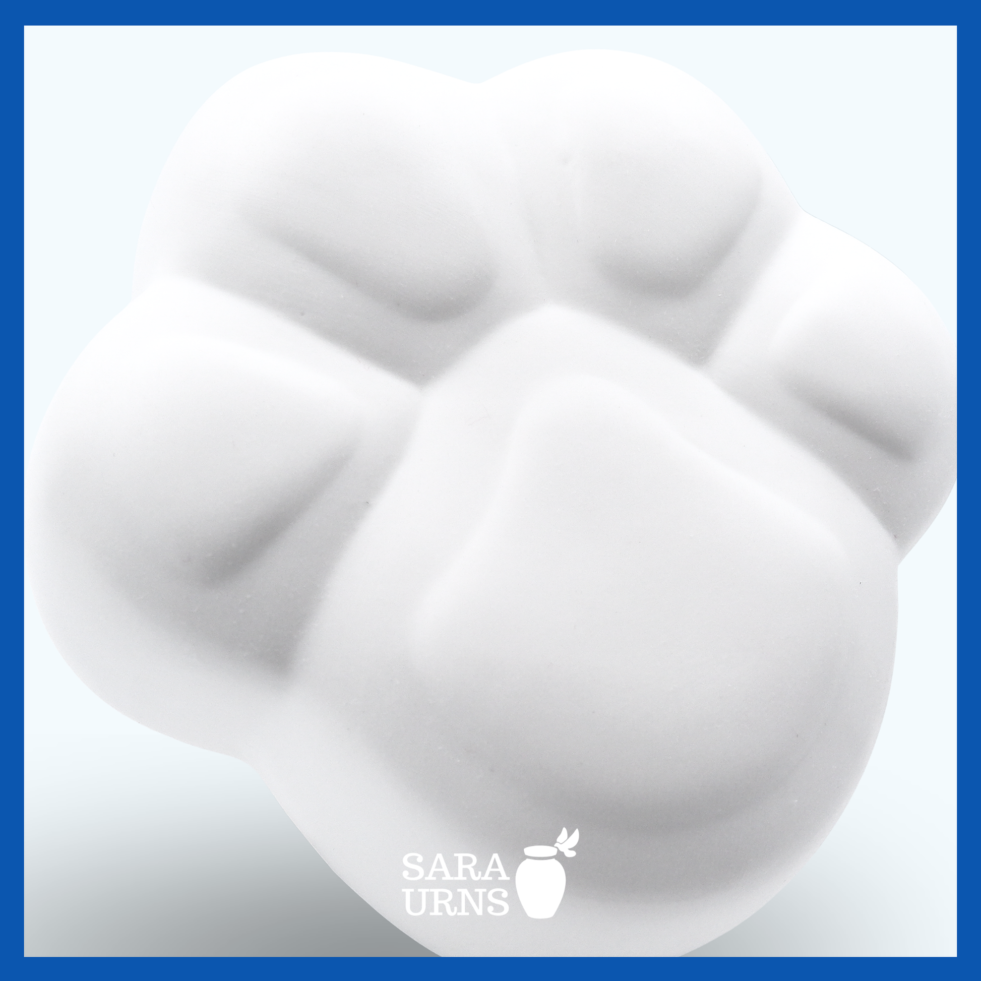 A higher angle of a paw-shaped, white ceramic pet urn with a matte finish.