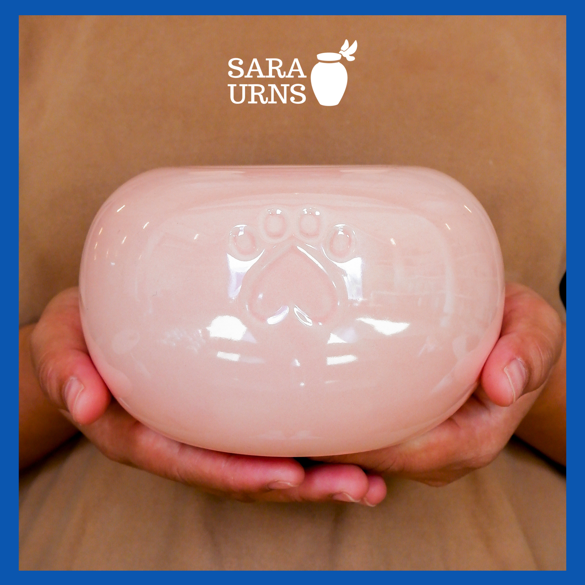 A presentation of a pink pearly ceramic pet urn held by an adult woman with two palms.
