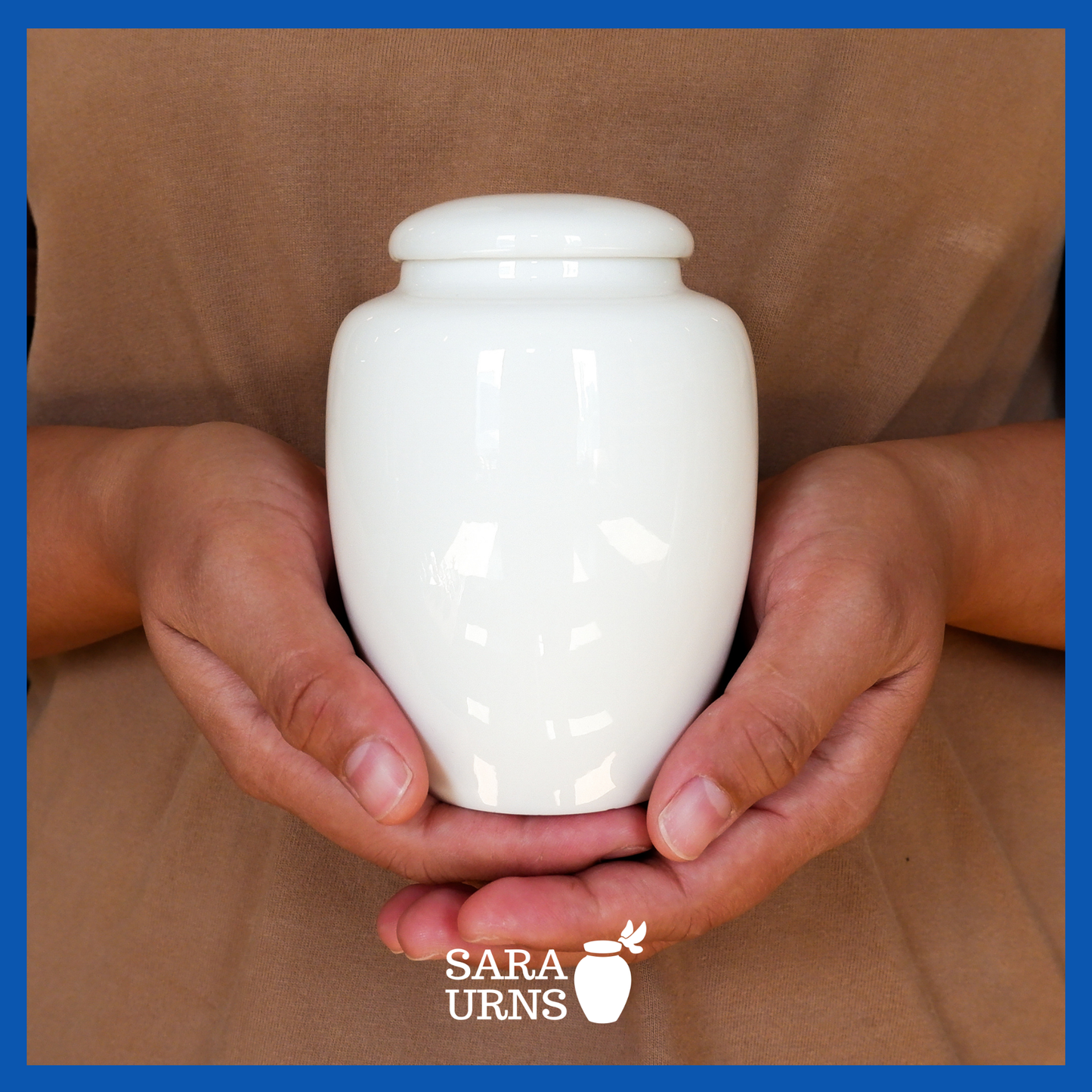 A presentation of an all-white polished ceramic baby urn held by an adult woman with two hands.