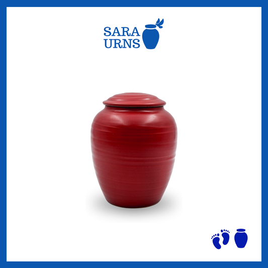 A red polished ceramic baby urn inspired by traditional, Japanese ceramics over a white background.