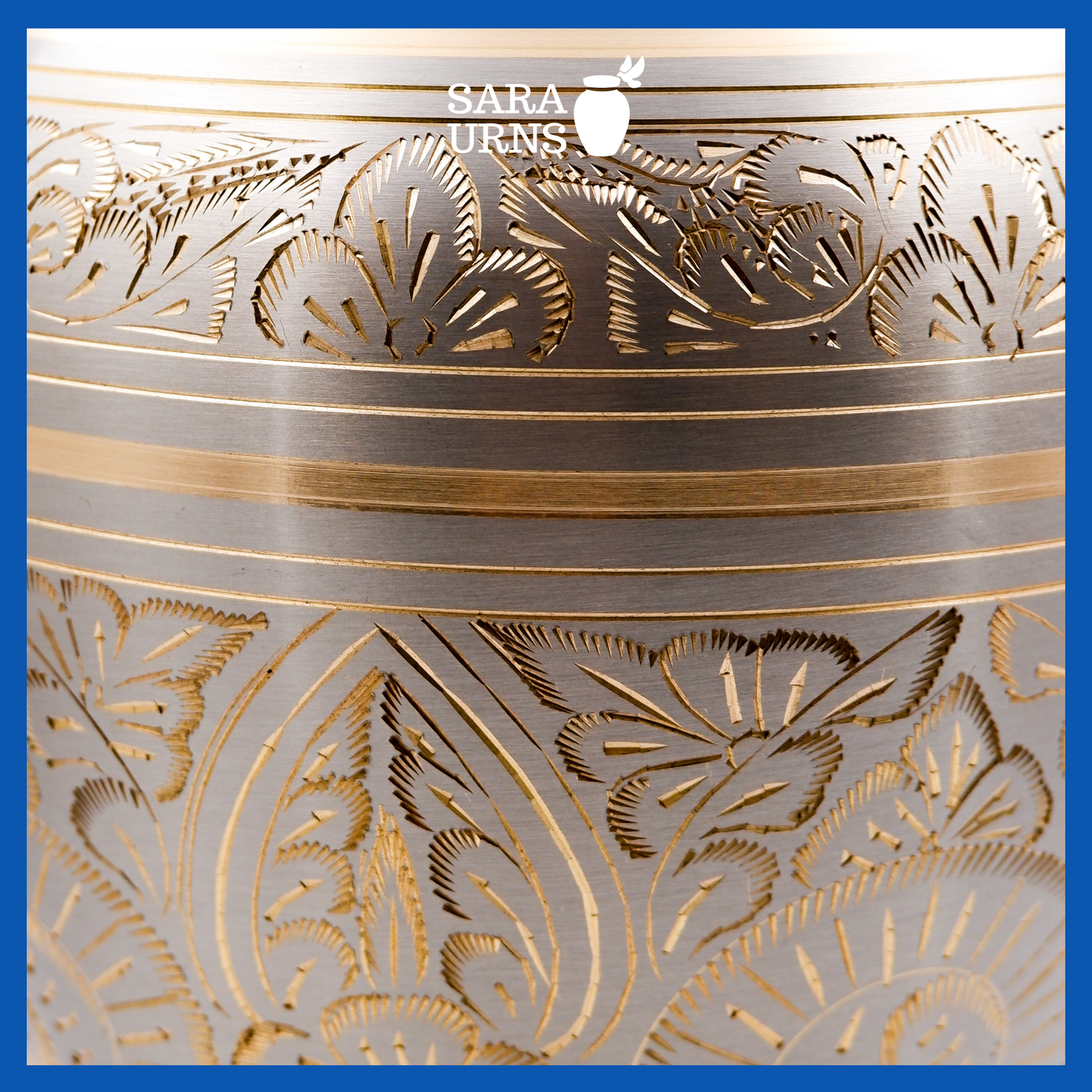 A platinum-bronze polished brass metal urn which highlights its golden hand-etched details across the lid and body.