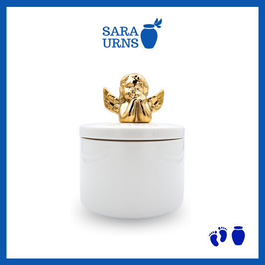 A white polished ceramic baby urn with a golden cherub on top of its lid over a white background.