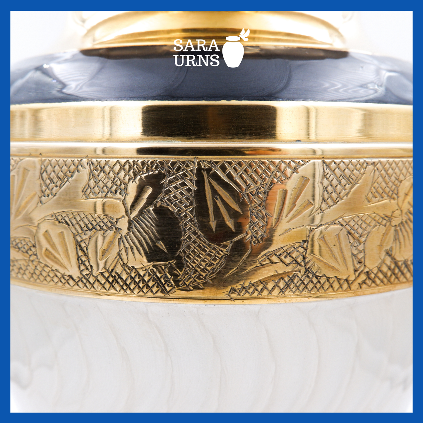 A close-up angle of A white polished brass metal urn which highlights its golden, hand-etched details.
