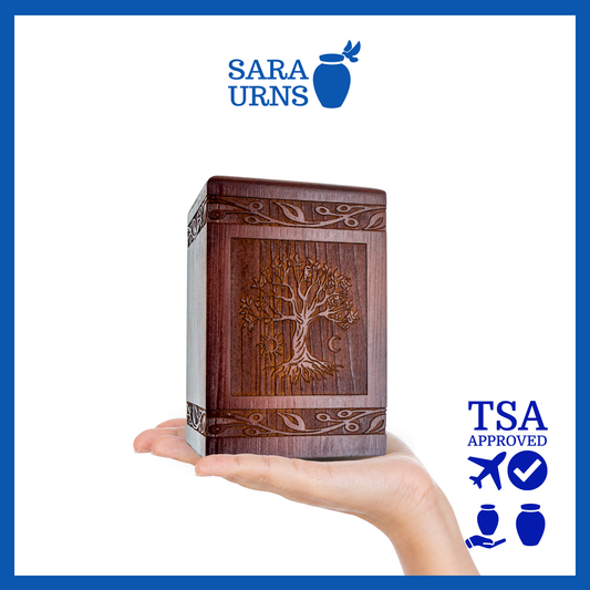 A brown pine wooden keepsake urn with an intricate engraving of the tree of life over a white background.