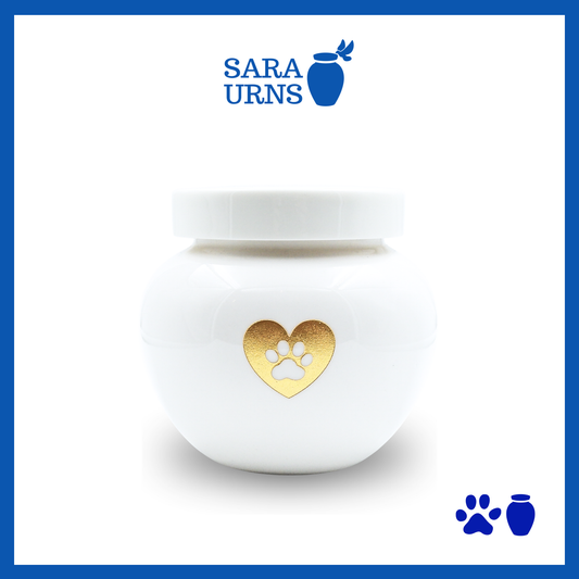 A white polished ceramic pet urn with a gold metallic foiled heart at its center over a white background.