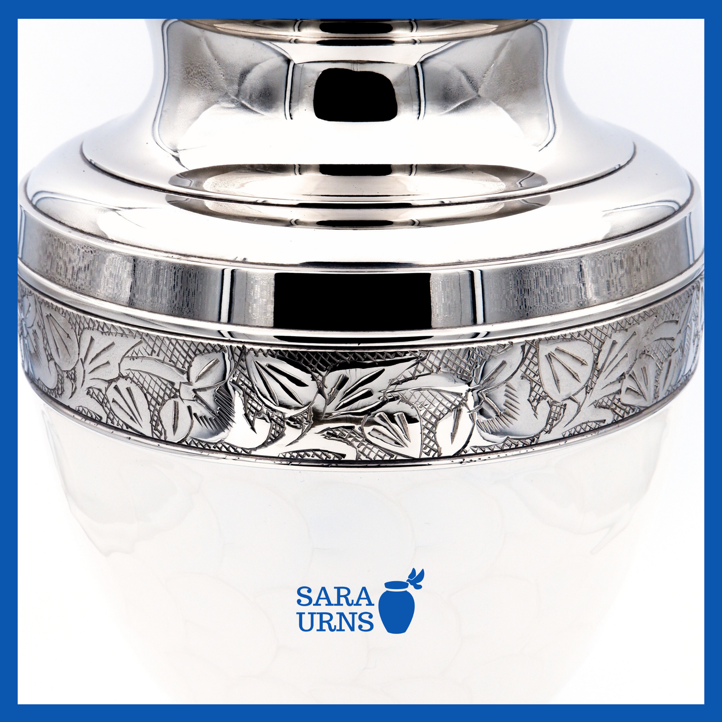 A close-up angle of a white polished brass metal urn which highlights its enamel finish and silver hand-etched details.
