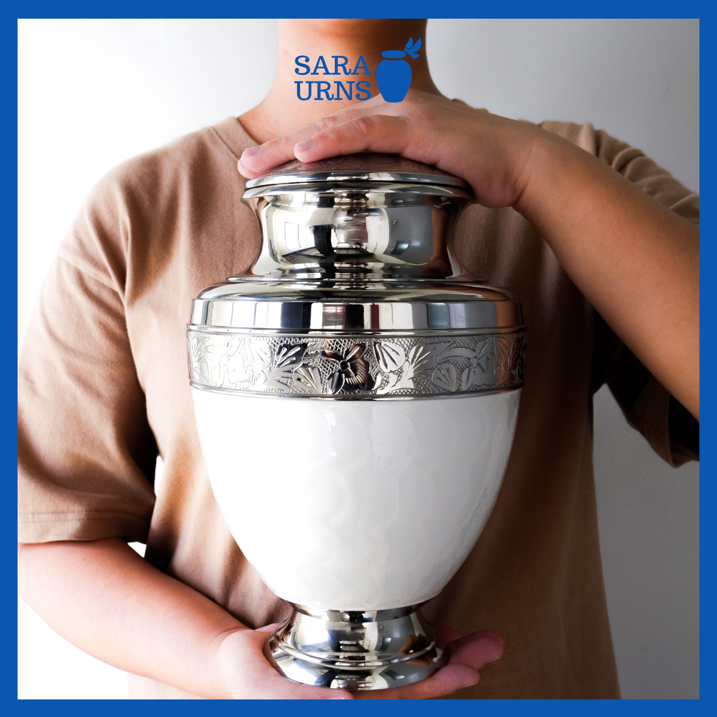 A presentation of a white polished brass metal urn held by an adult woman with two hands.