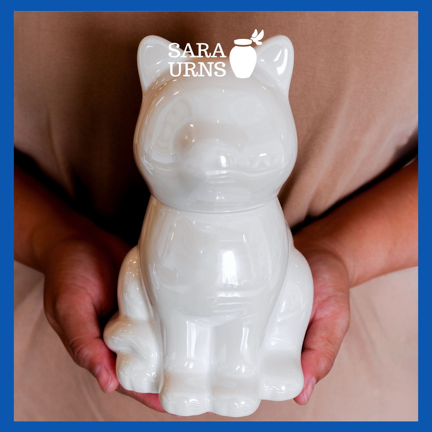 A presentation of a white ceramic pet urn with a cat-shaped silhouette held by an adult woman with two hands.