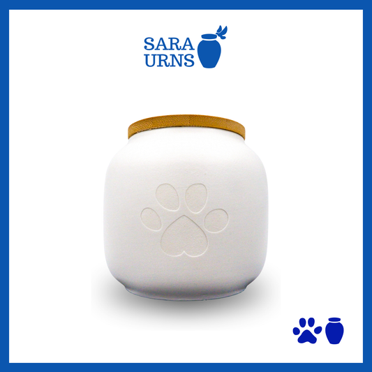 A white ceramic pet urn with a matte finish, an embossed paw at its center and a bamboo lid over a white background.