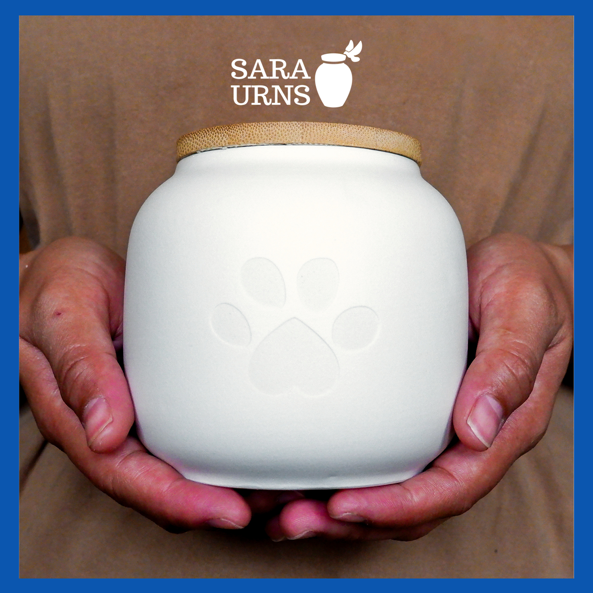 A presentation of a white ceramic pet urn held by an adult woman with two palms.