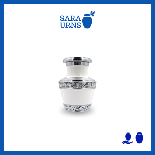 A white aluminum metal keepsake urn with silver hand-etched designs across the body and lid over a white background.