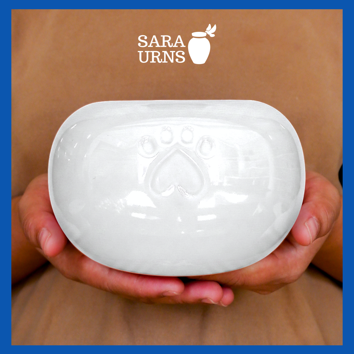 A presentation of a white pearly ceramic pet urn held by an adult woman with two palms.