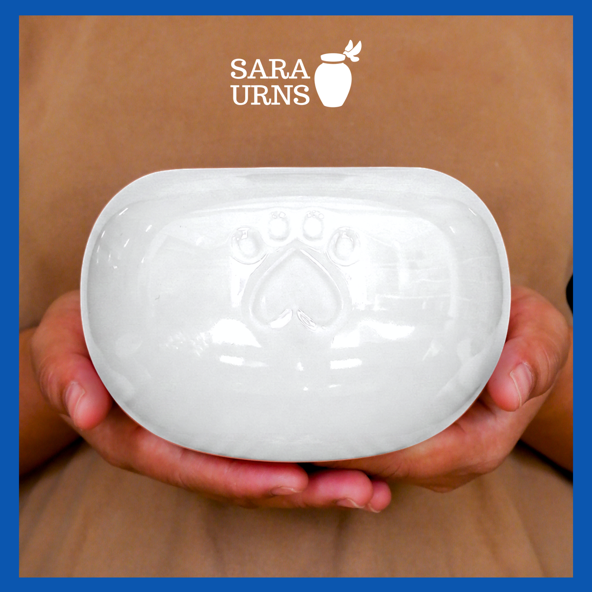A presentation of a white pearly ceramic pet urn held by an adult woman with two palms.